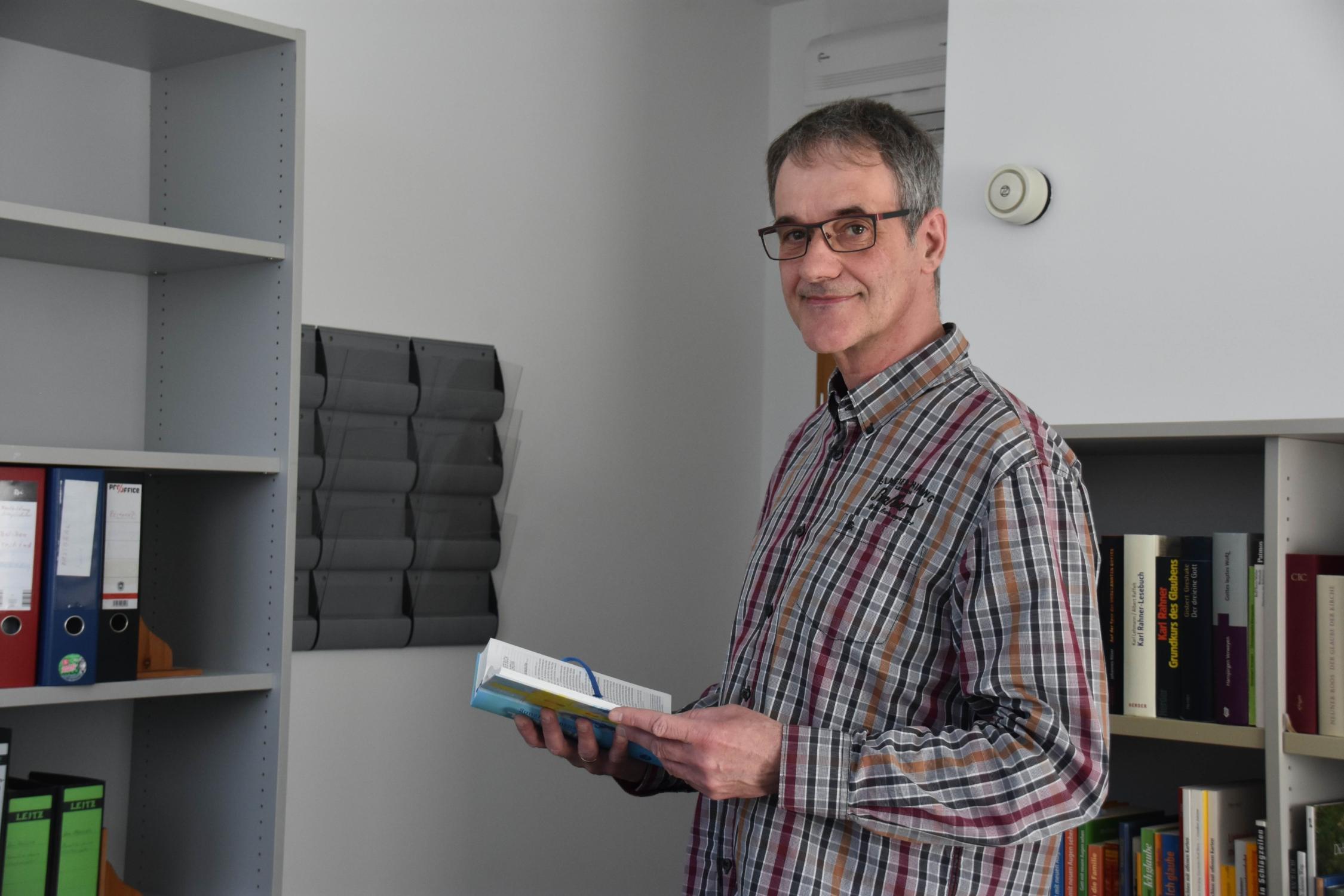Diözesanreferent Volker Kandziora Oberkörperansicht mit Buch in der Hand